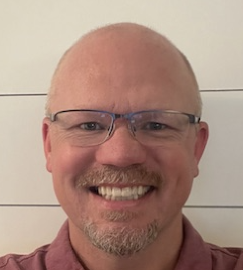 white male with glasses smiling