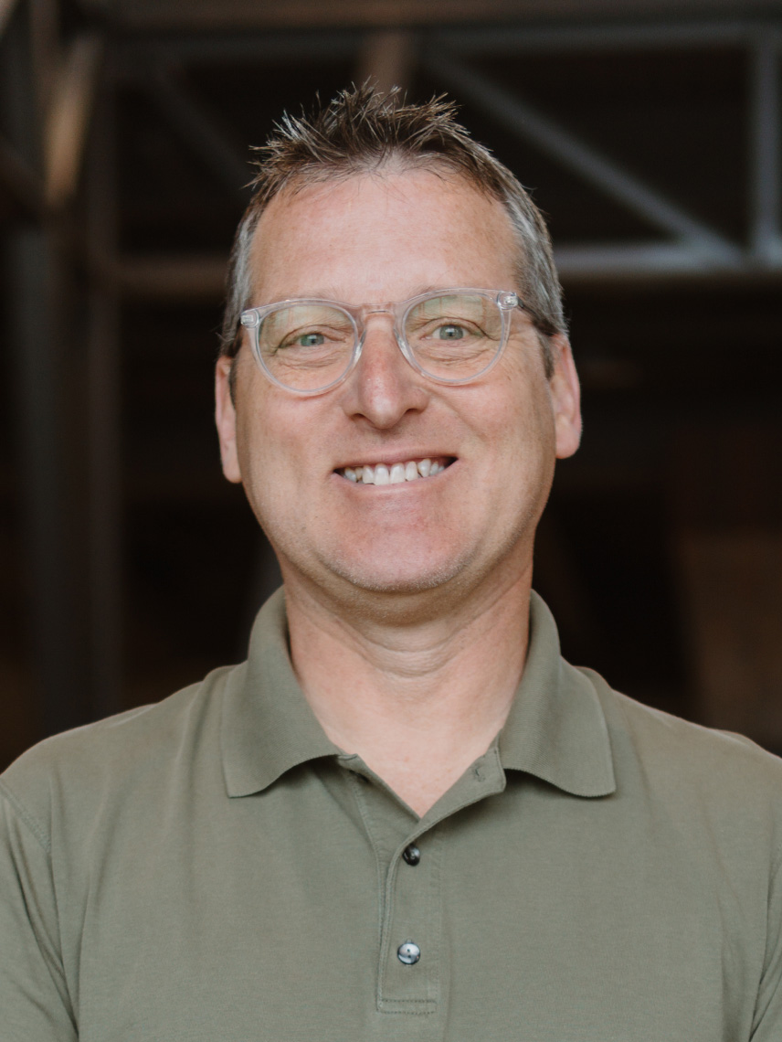 white male with glasses smiling