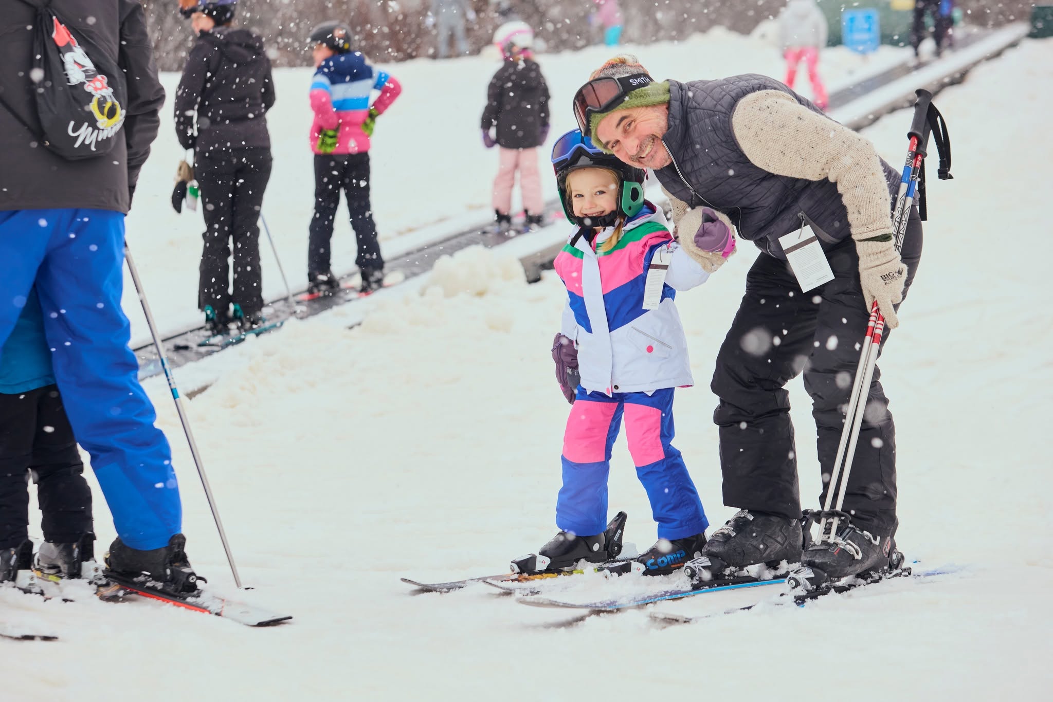 Middle aged man and young girl ready to ski in the snow