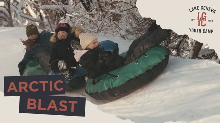Three teens riding green tubes in the snow, with the the words "Arctic" and "Blast" in the bottom, left corner.