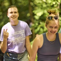 two blonde, young adult women hiking and smiling