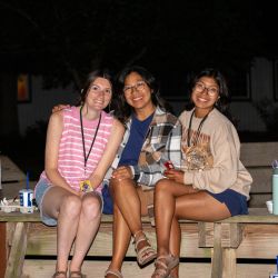 three women sitting outside at night