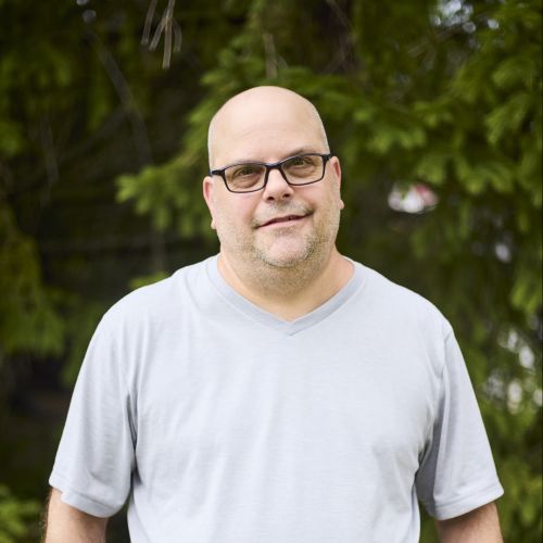 white male with glasses smiling