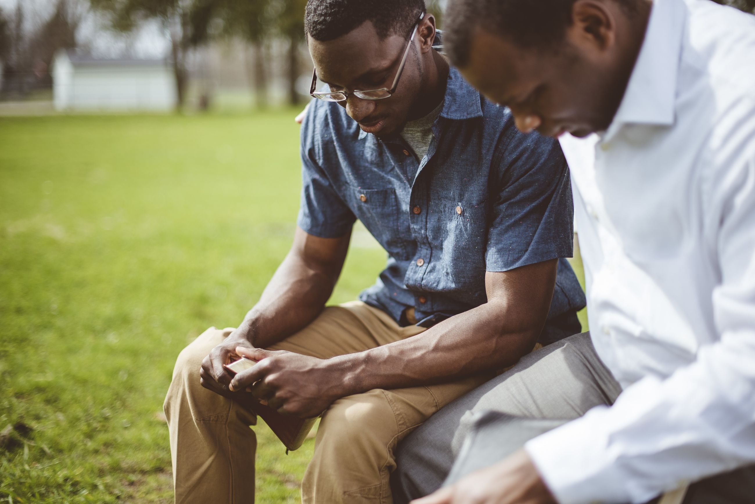 Two African-American men praying together.
